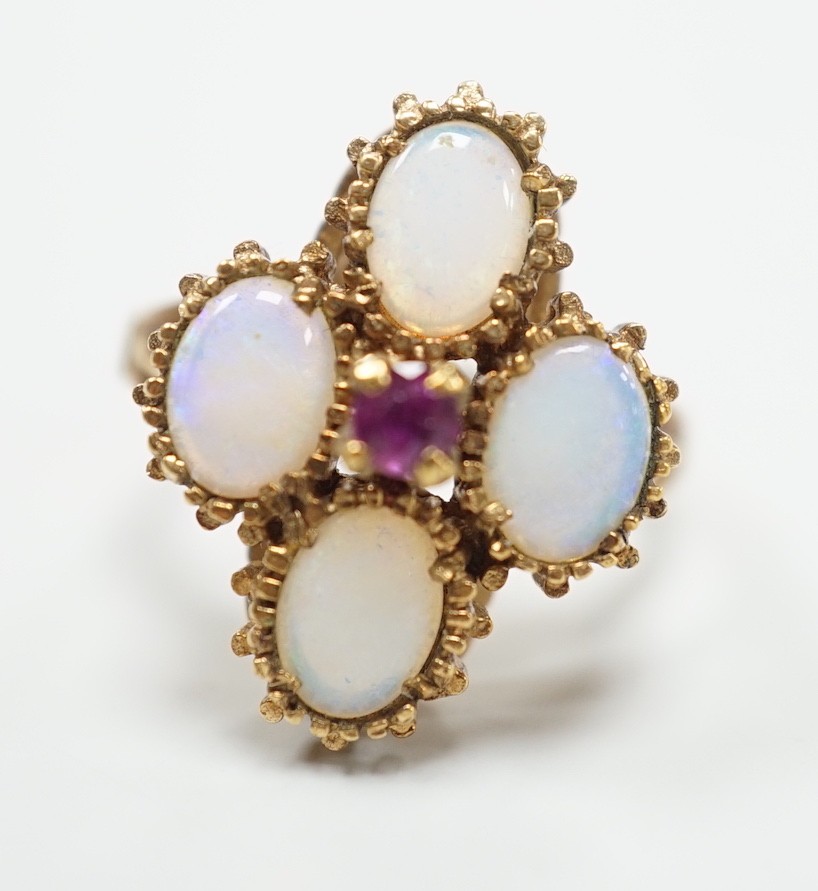 A 1970's 9ct gold, four stone white opal and single stone ruby cluster set dress ring, size O, gross weight 5.2 grams.